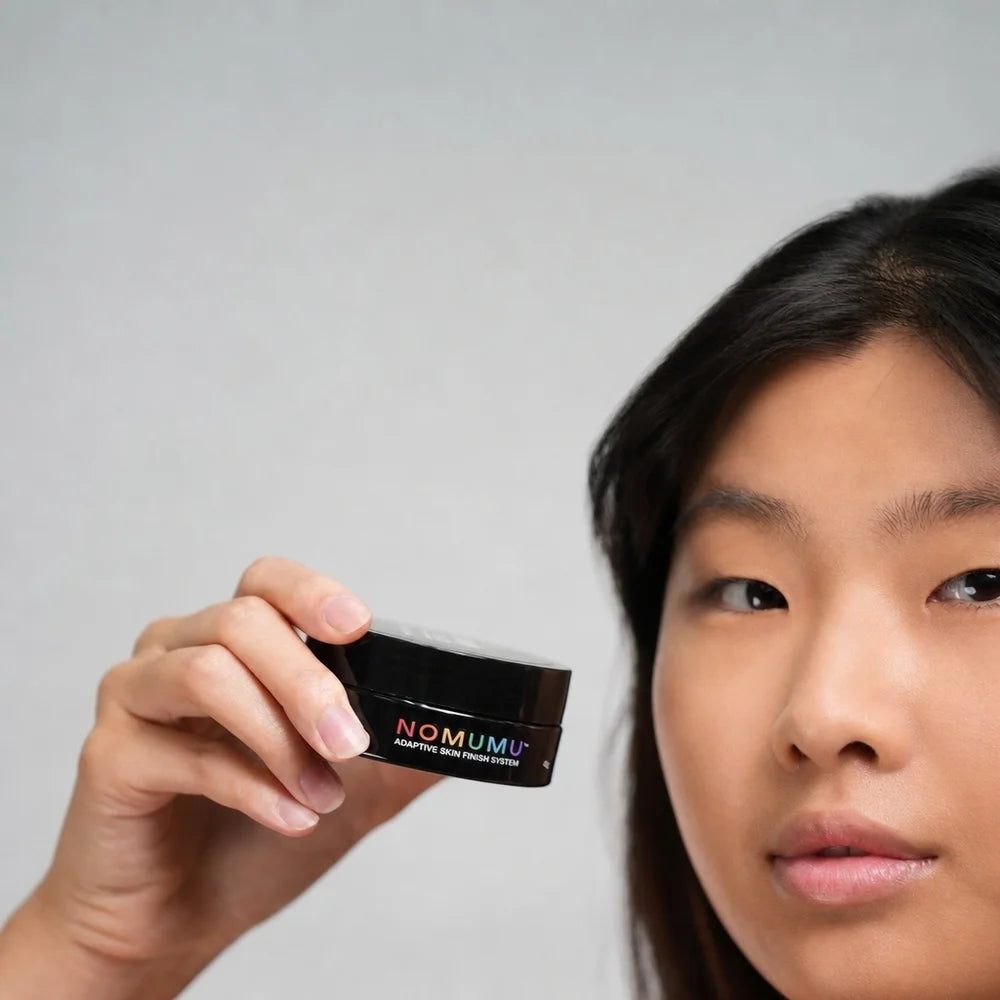 Model holding NOMUMU Tinted Skincare base jar close up